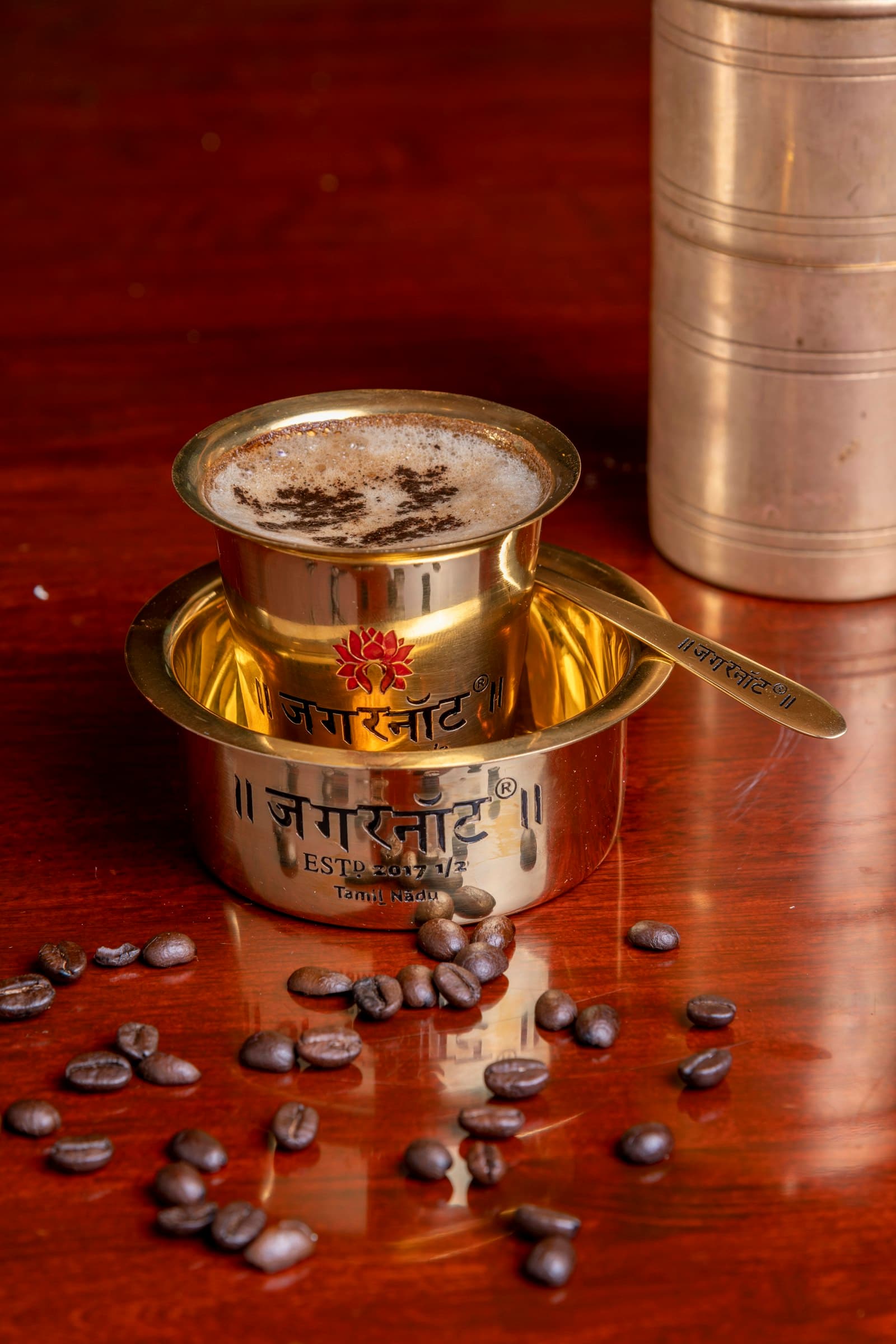 A brass davara and tumbler set with coffee beans