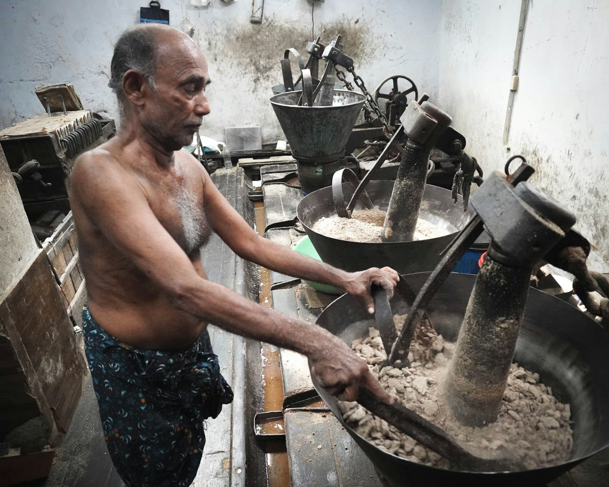 A cook working at a traditional stone grinder