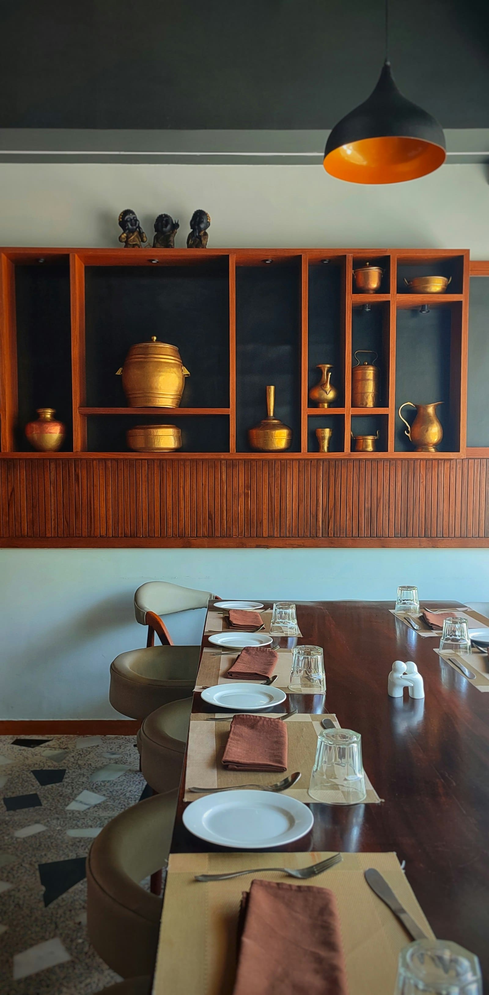 Brass vessels arranged on a wooden shelf in the café